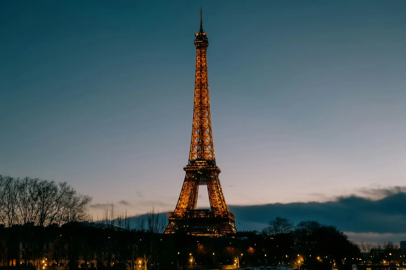 Torre Eiffel iluminada ao entardecer em Paris