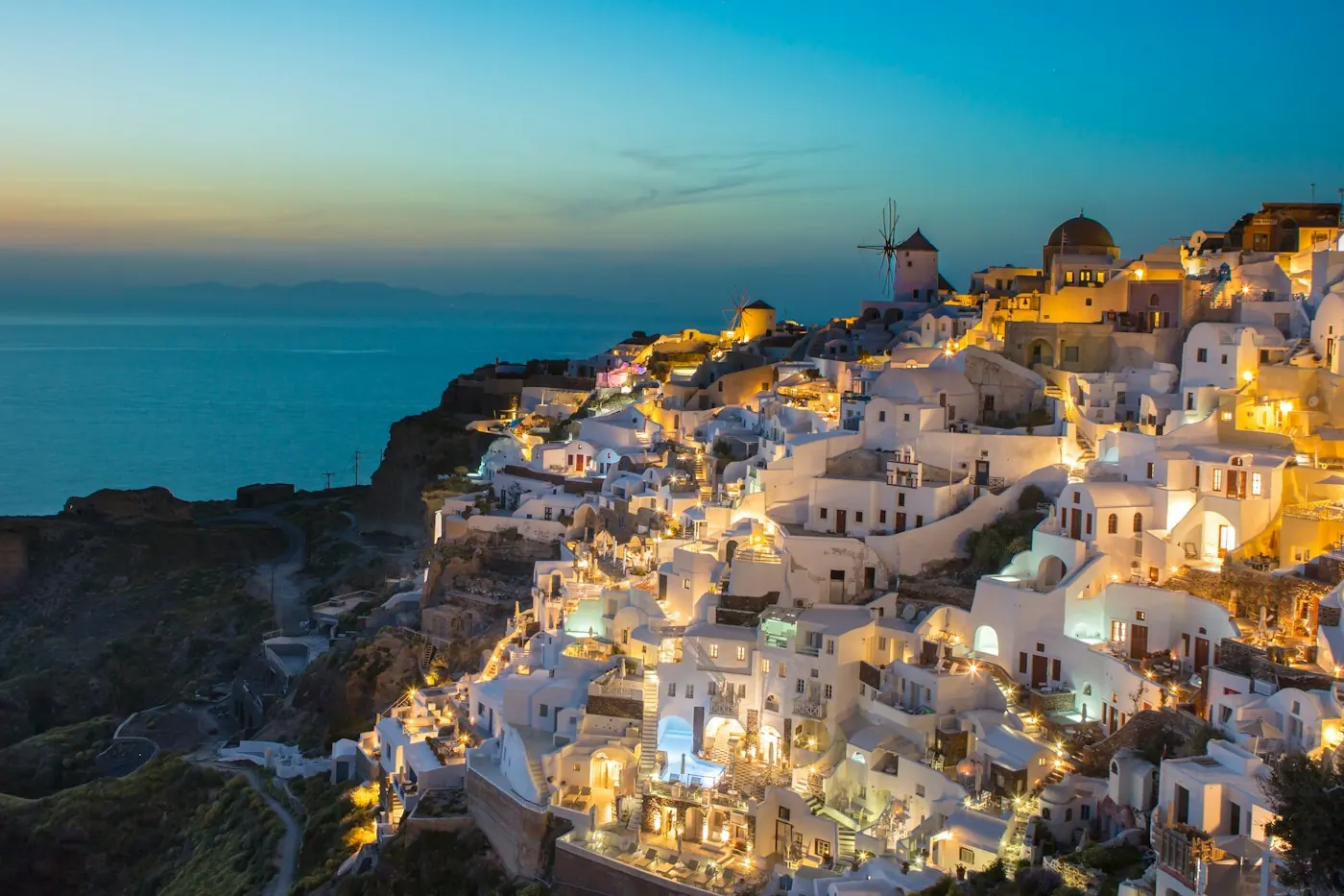 Vila de Oia iluminada ao anoitecer em Santorini